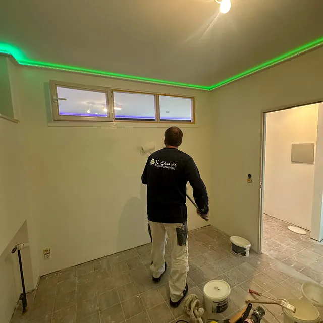 Mitarbeiter streicht Wand