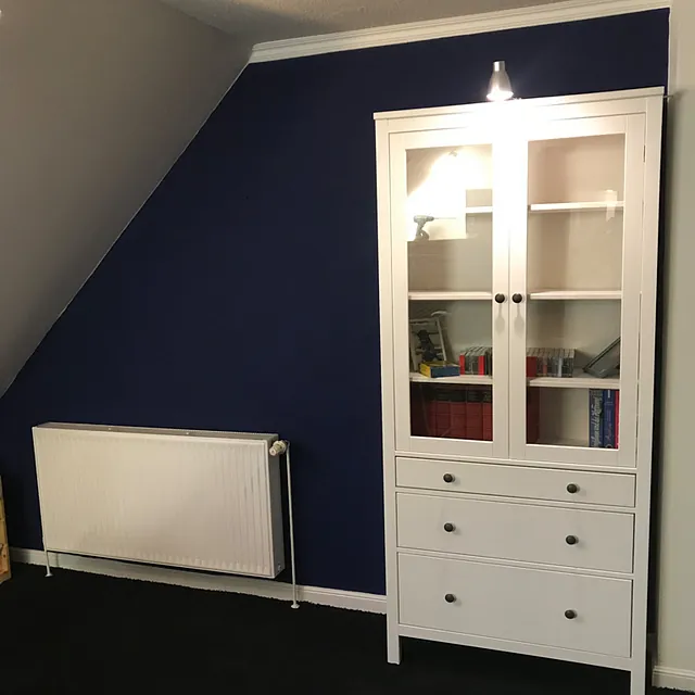 Blaugestrichene Wand und weißer Schrank